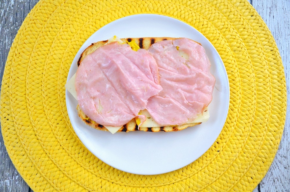 hot dog bun with mustard, Swiss cheese and ham
