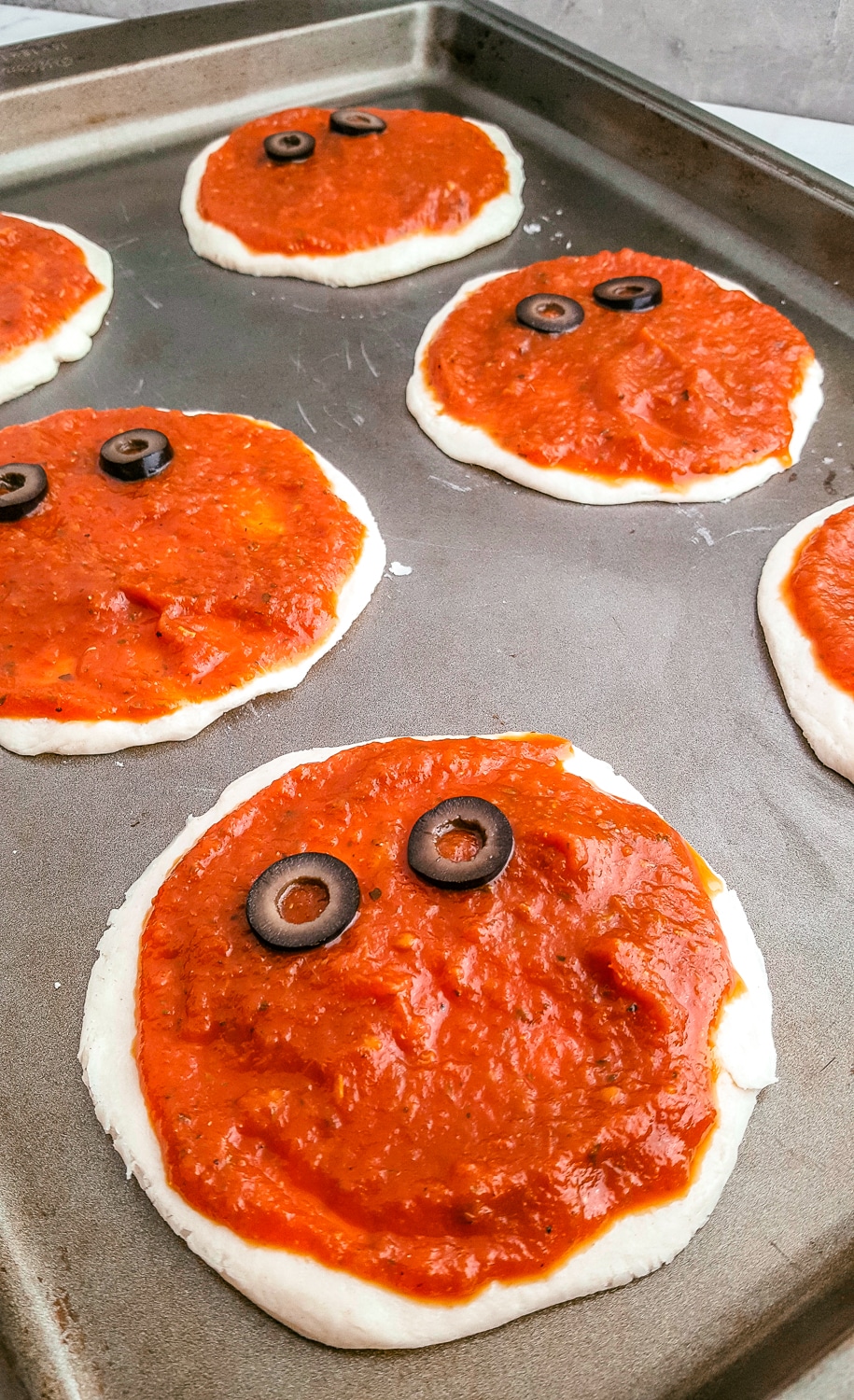 mummy pizza with tomato sauce and sliced olives for eyes