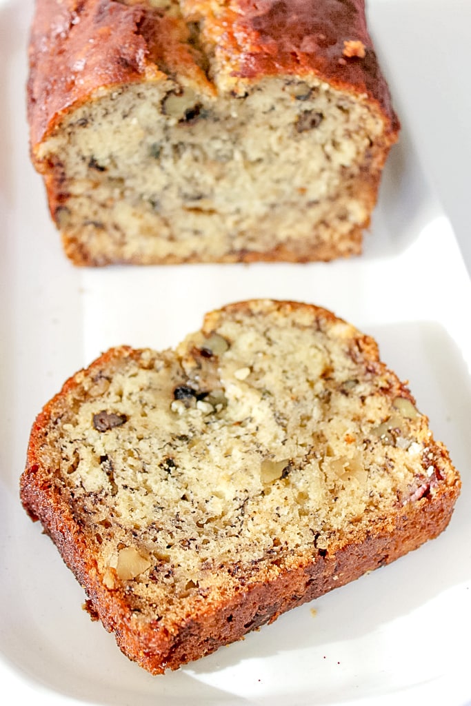 Baked banana bread sliced on a white tray.