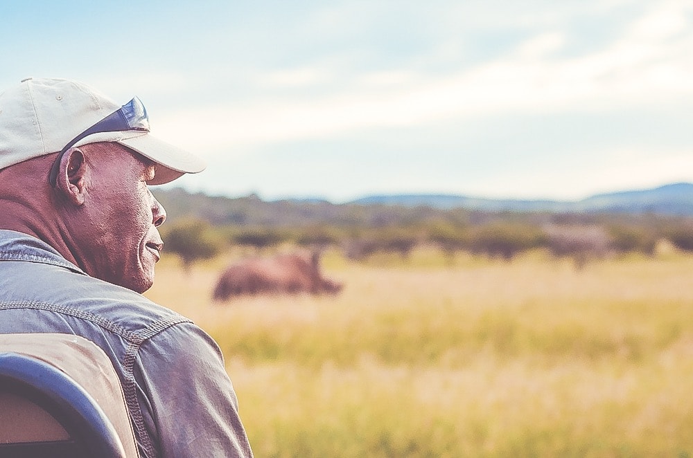 Thanda Safari tracker looking on to savanna 