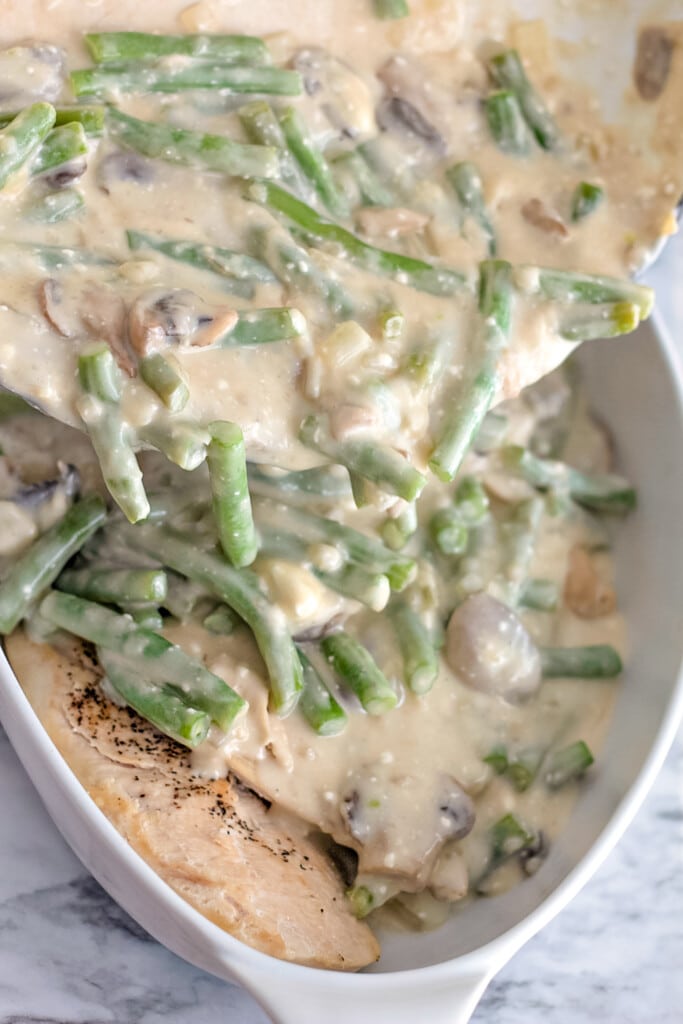 baked chicken topped with green beans and mushrooms in a cream sauce