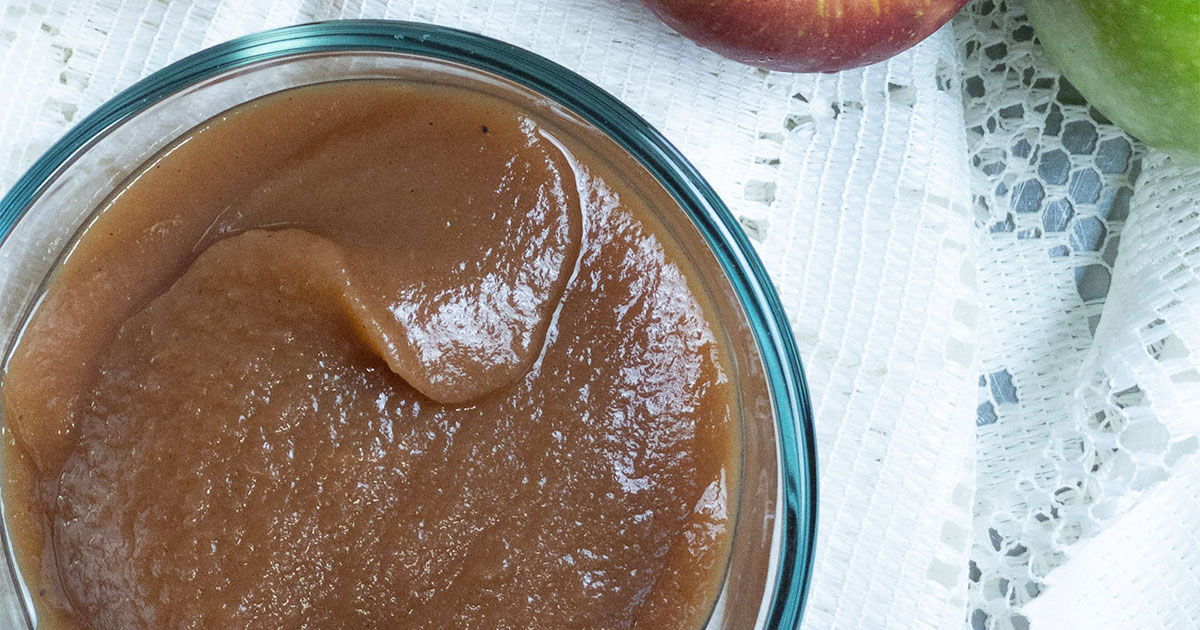 apple butter in a bowl on a table with lace