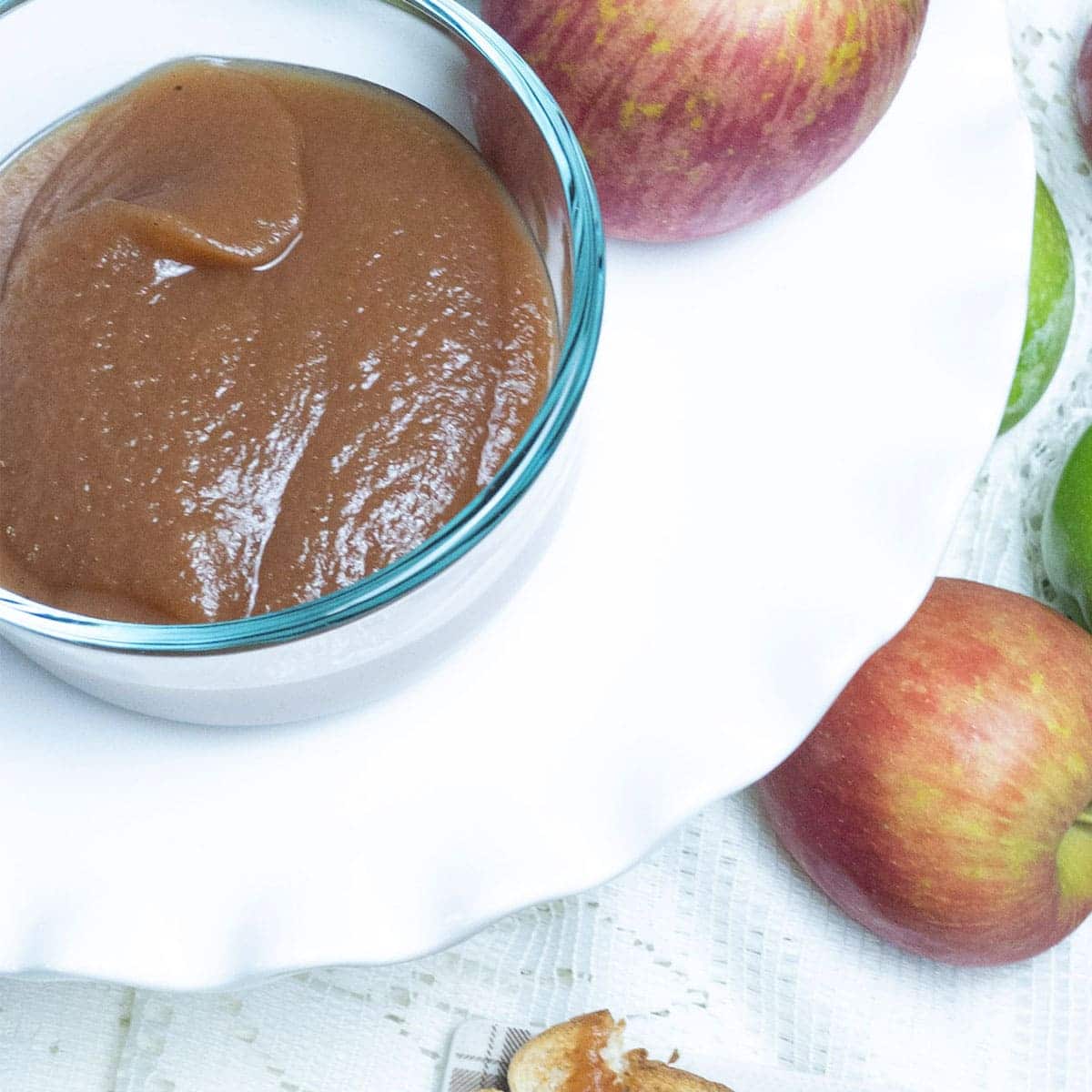 apple butter in a bowl on a table with some apples