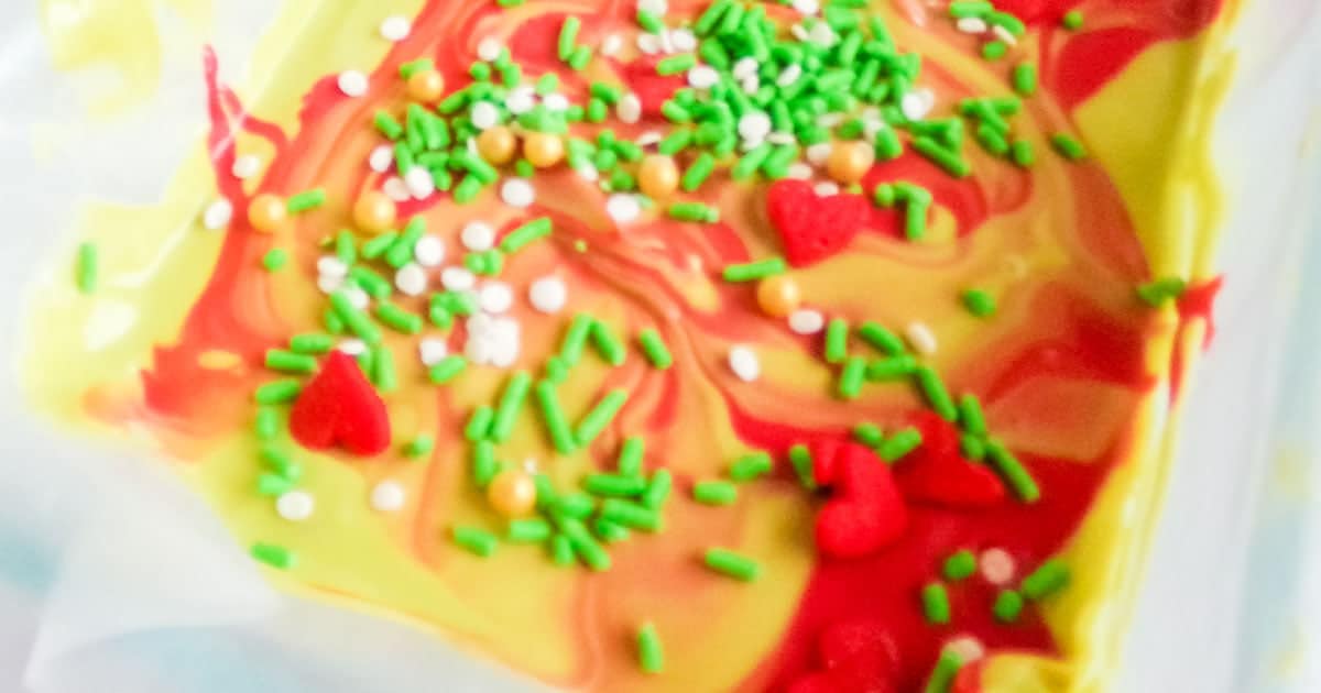 in-process step of adding sprinkles to decorate grinch bark for grinch movie night