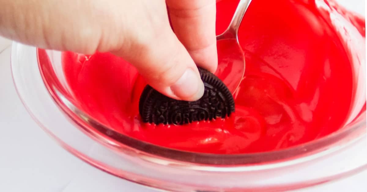 OREO cookies being dipped in chocolate to make Mickey christmas cookies