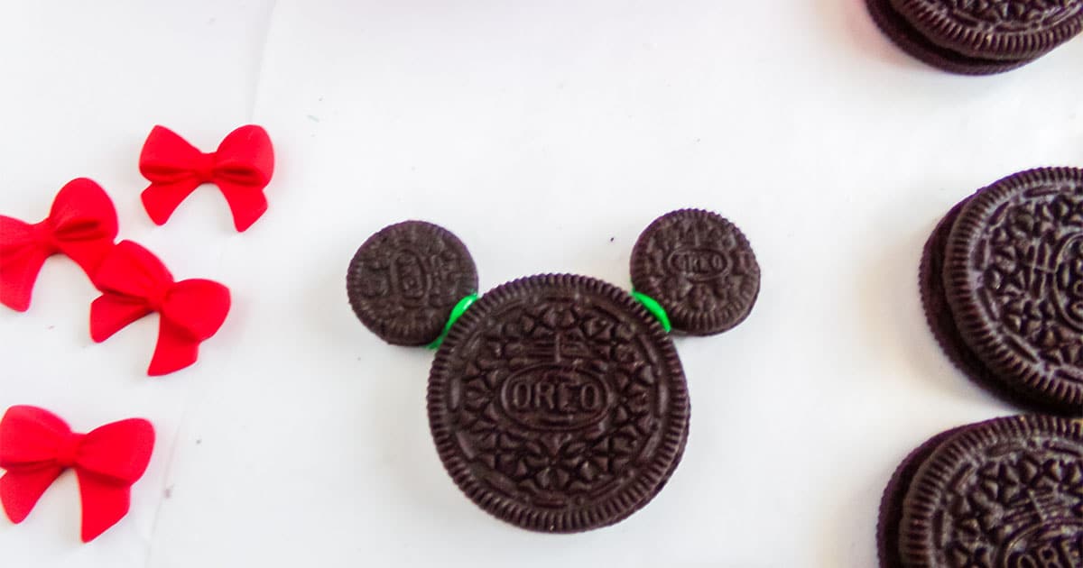 in-process step of adding ears to make mickey mouse cookies for christmas