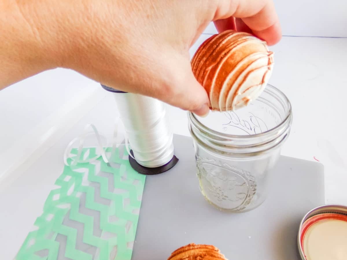 filling a jar to make a Mason Jar Gift Hot Cocoa Bombs