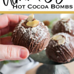 hand holding a diy hot cocoa bomb with text which reads Almond Joy Hot Cocoa Bombs