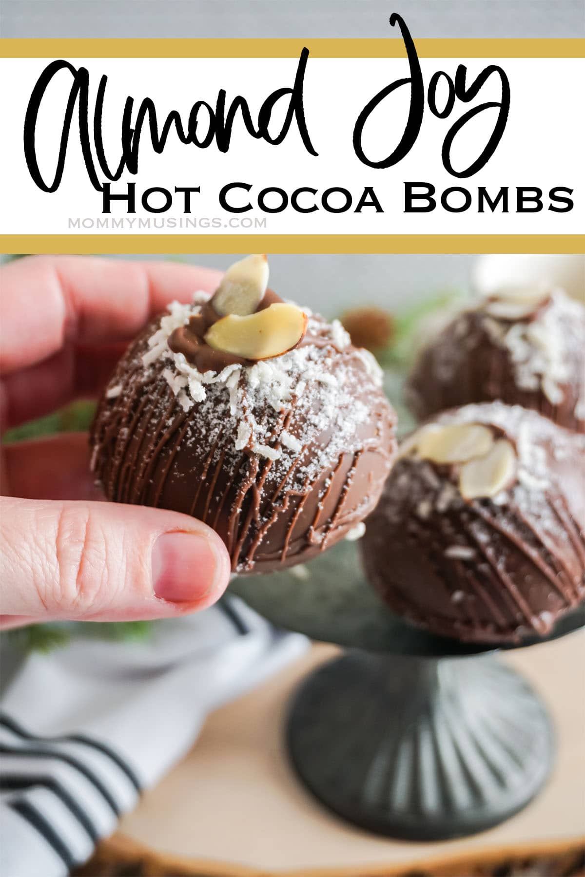 hand holding a diy hot cocoa bomb with text which reads Almond Joy Hot Cocoa Bombs