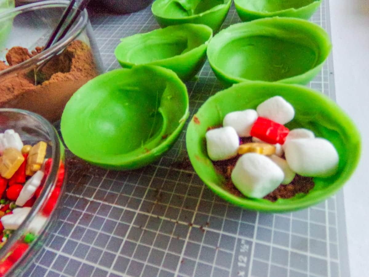 filling Christmas Hot cocoa bombs with marshmallows