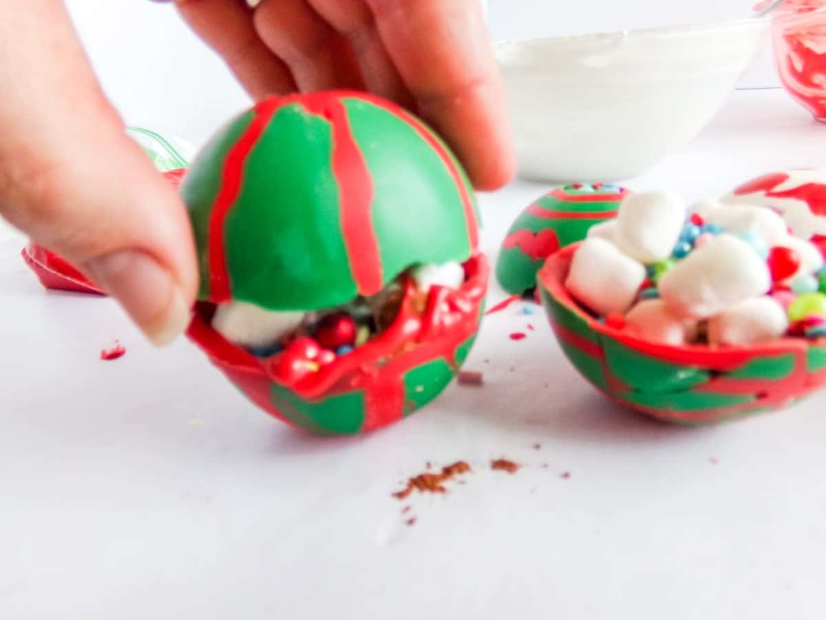 in-process step of closing up Christmas Ornament Hot cocoa bombs