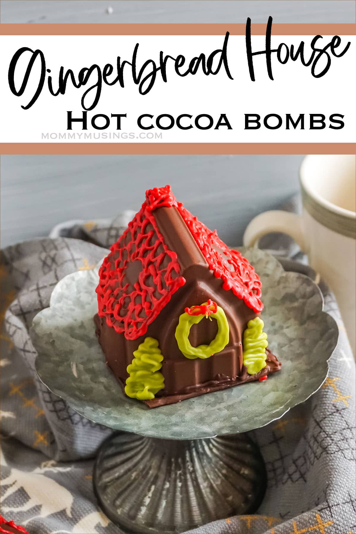 gingerbread house hot chocolate bomb on a cupcake stand with text which reads Gingerbread House Hot Cocoa Bombs