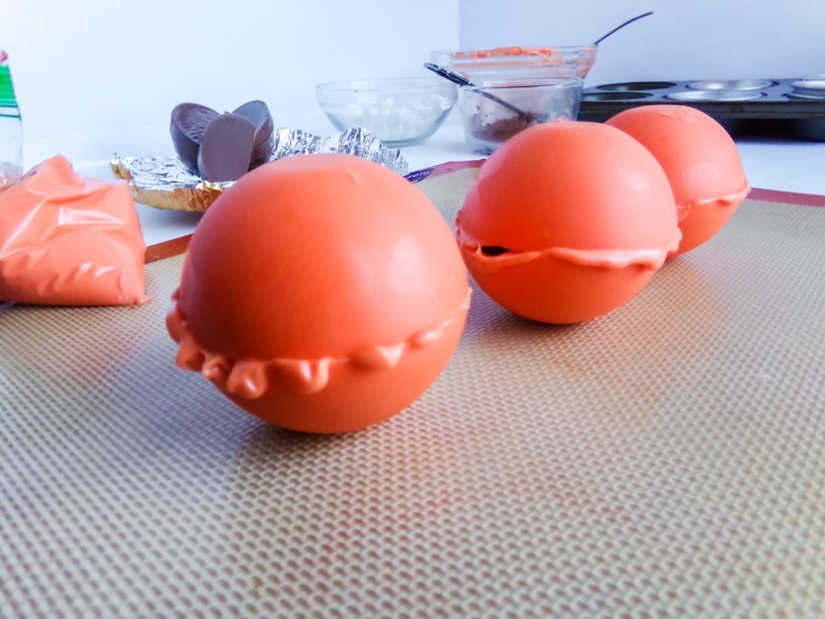 attaching the tops of Orange Slice Candy Hot Cocoa Bombs