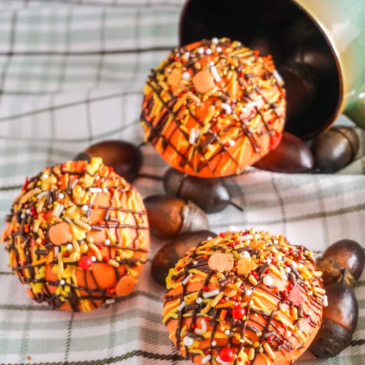 pumpkin spice hot cocoa bombs spilling out of a mug