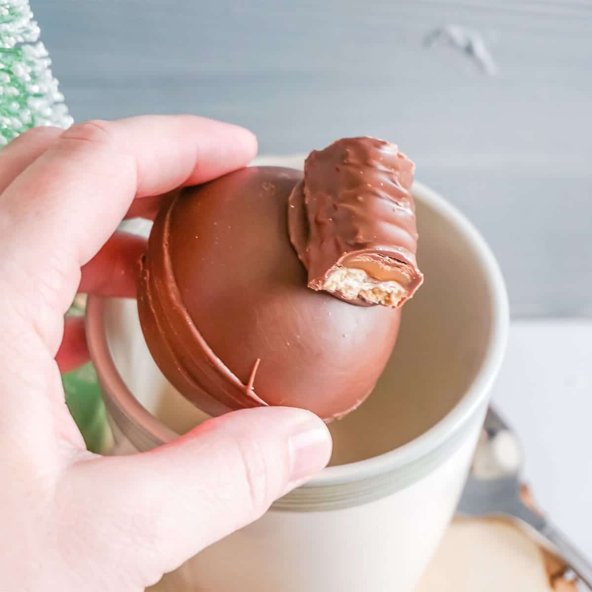 twix hot cocoa bombs being put into a mug