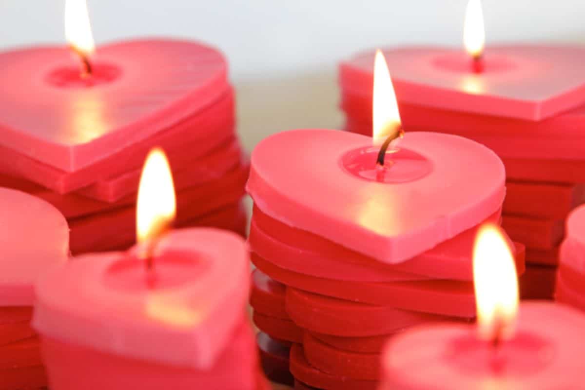 piles of red wax hearts are stacked and lit with a flame