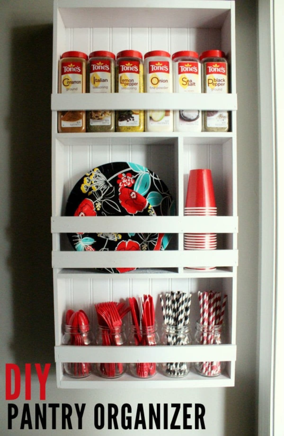 The inside of a cupboard is show, made of white wood. On the shelves are pantry items and storage goods.