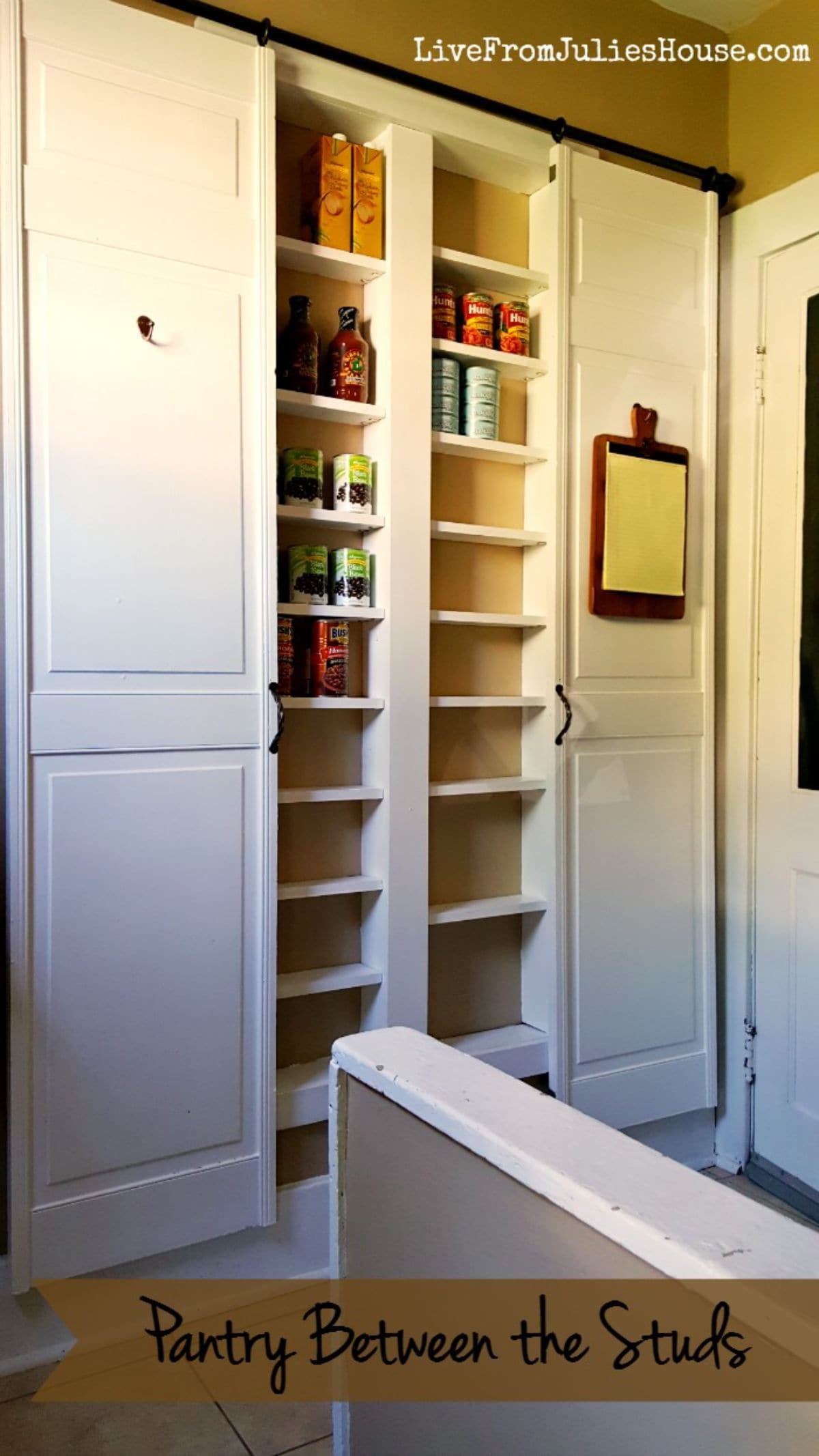 In between two white cabinets are two cut away spaces filled with shallow shelves.