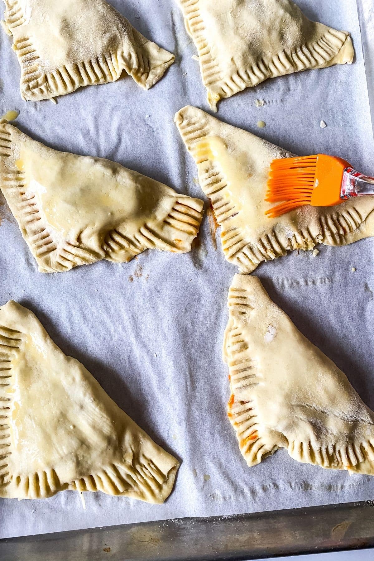 Brushing tops of puff pastry with egg