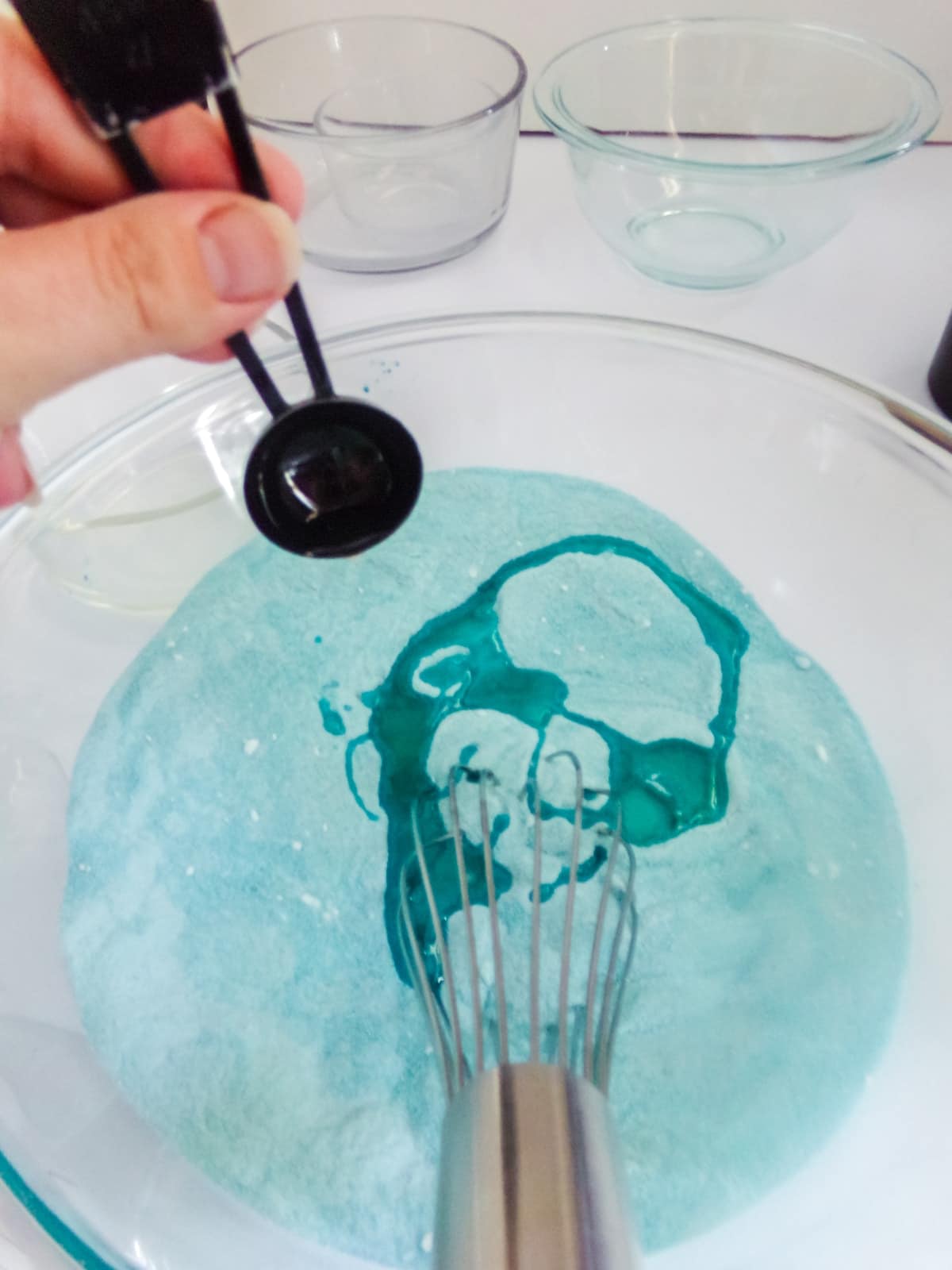 adding ingredients to make mermaid DIY bath bomb
