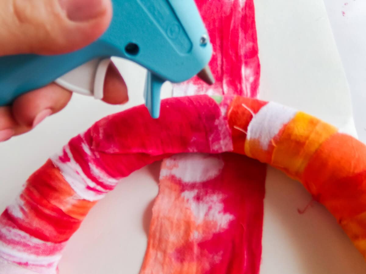 wrapping a wreath form to make a summer watermelon wreath with cricut