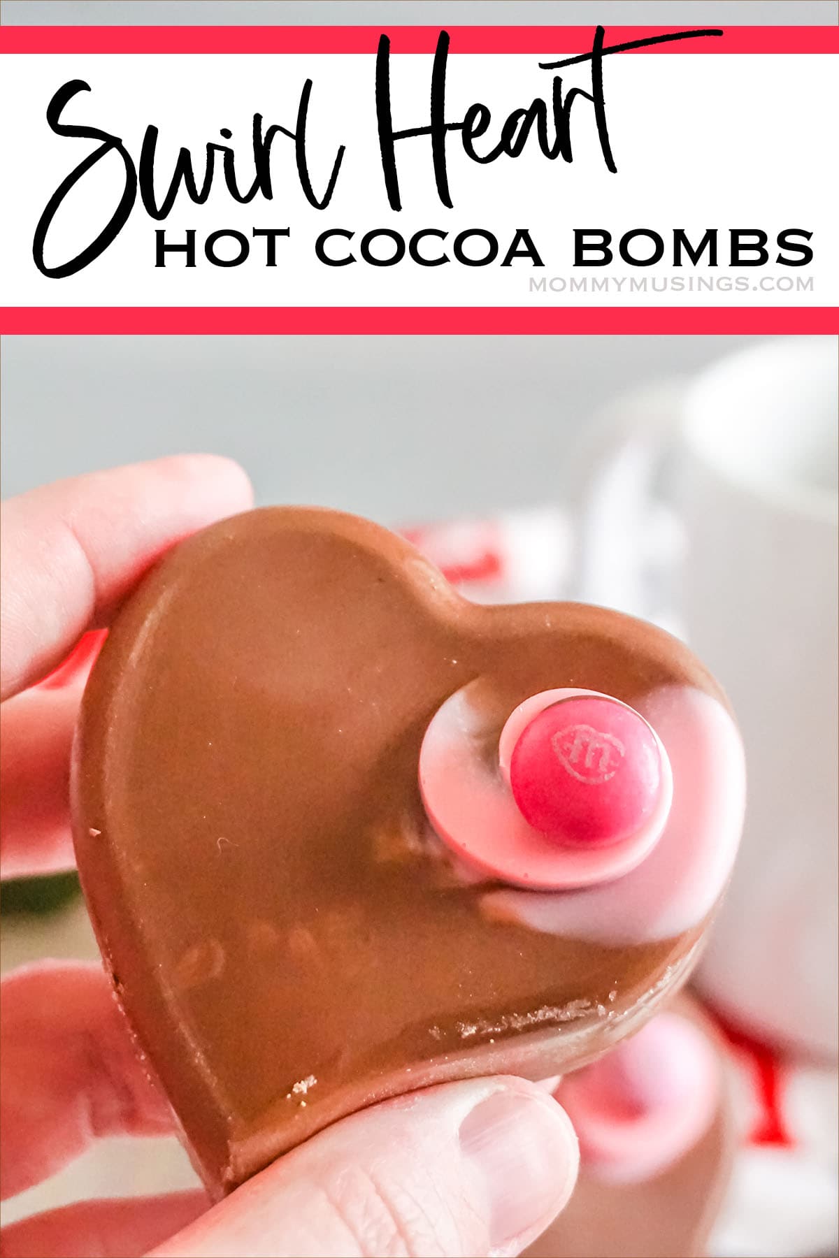 hand holding a heart shaped hot cocoa bombs with text which reads swirl heart hot cocoa bombs