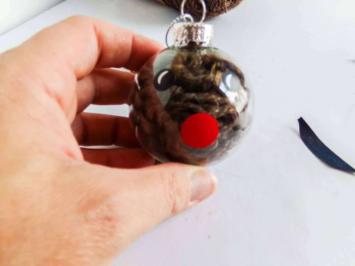 in-process step of attaching vinyl to a glass ornament to make a reindeer christmas ornament