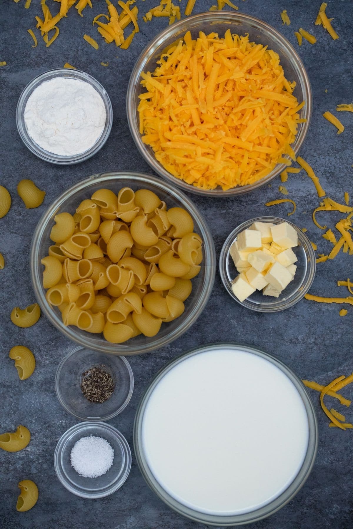 glass bowls of pasta milk and cheese on gray table