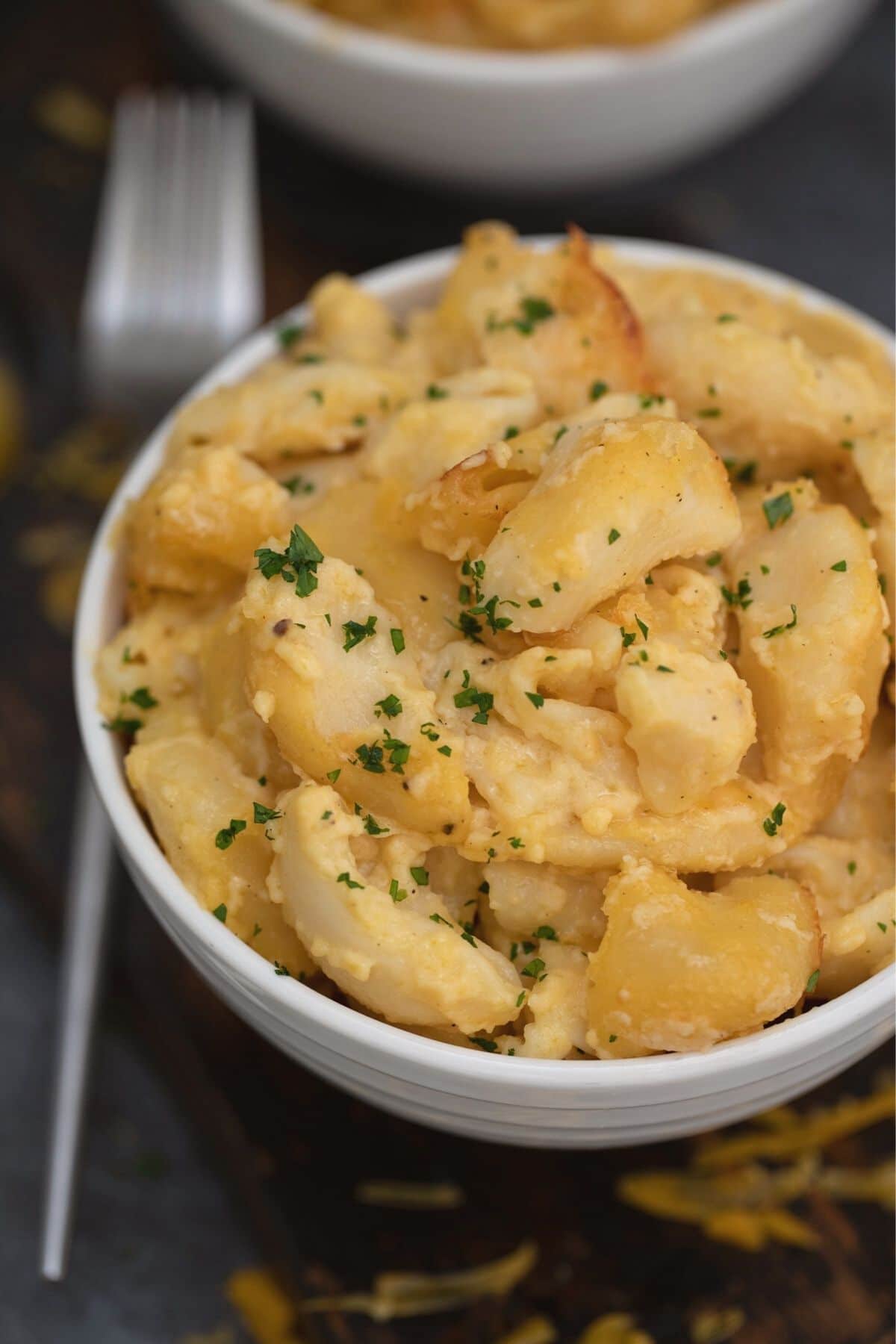 white bowl of mac and cheese with parsley on top