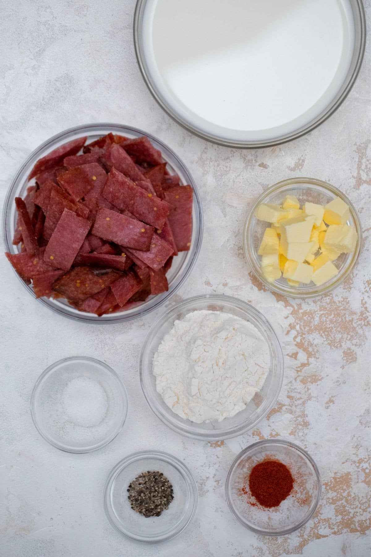 glass bowls of spices and beef on marble table