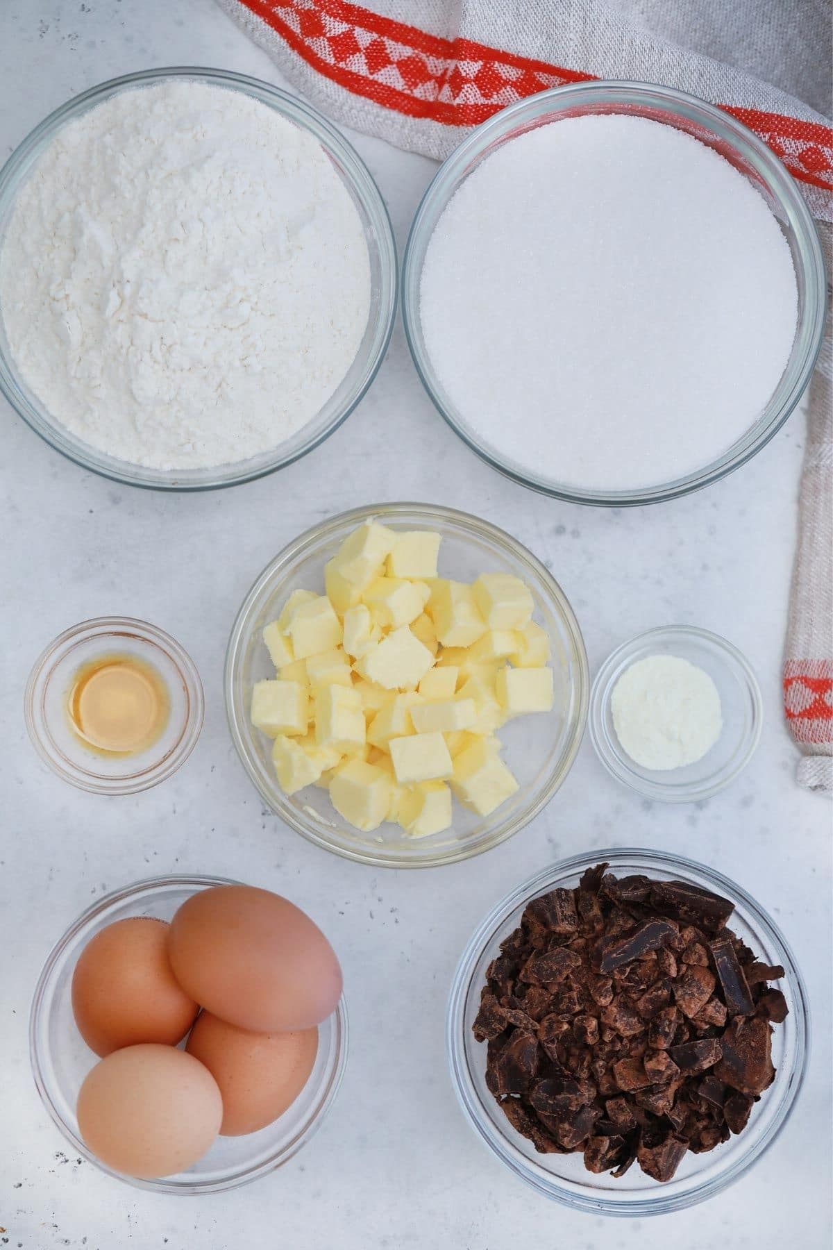 glass bowls of flour sugar butter and chocolate on marble table