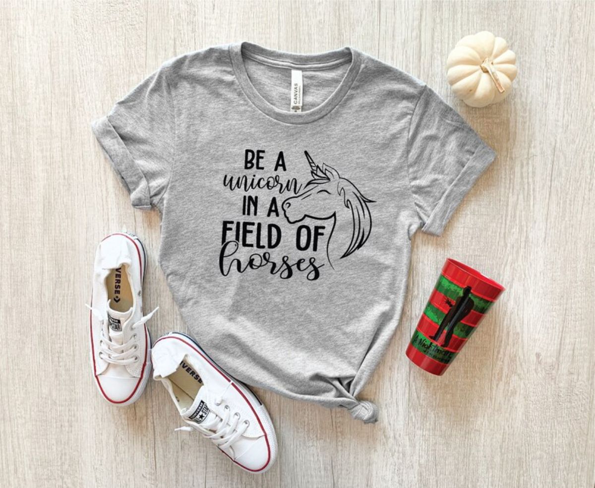gray tshirt with writing next to white shoes and red cup