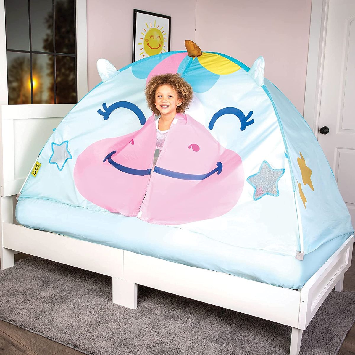 unicorn bed tent on white bed with girl poking head out of opening