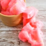 pink slime with jelly cubes spilling out of a cup onto a table