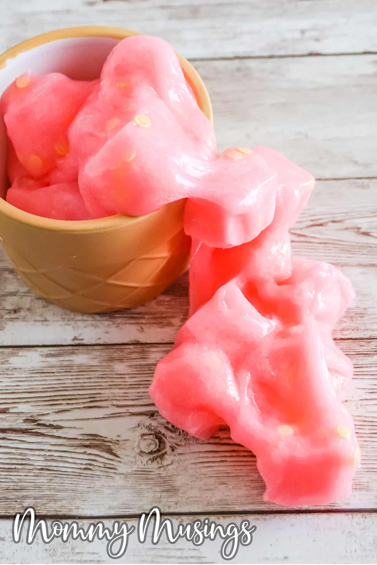 pink slime with jelly cubes spilling out of a cup onto a table