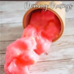 easy diy jelly cube slime spilling out of a cup onto a table with text which reads Pink Lemonade Jelly Cube Slime