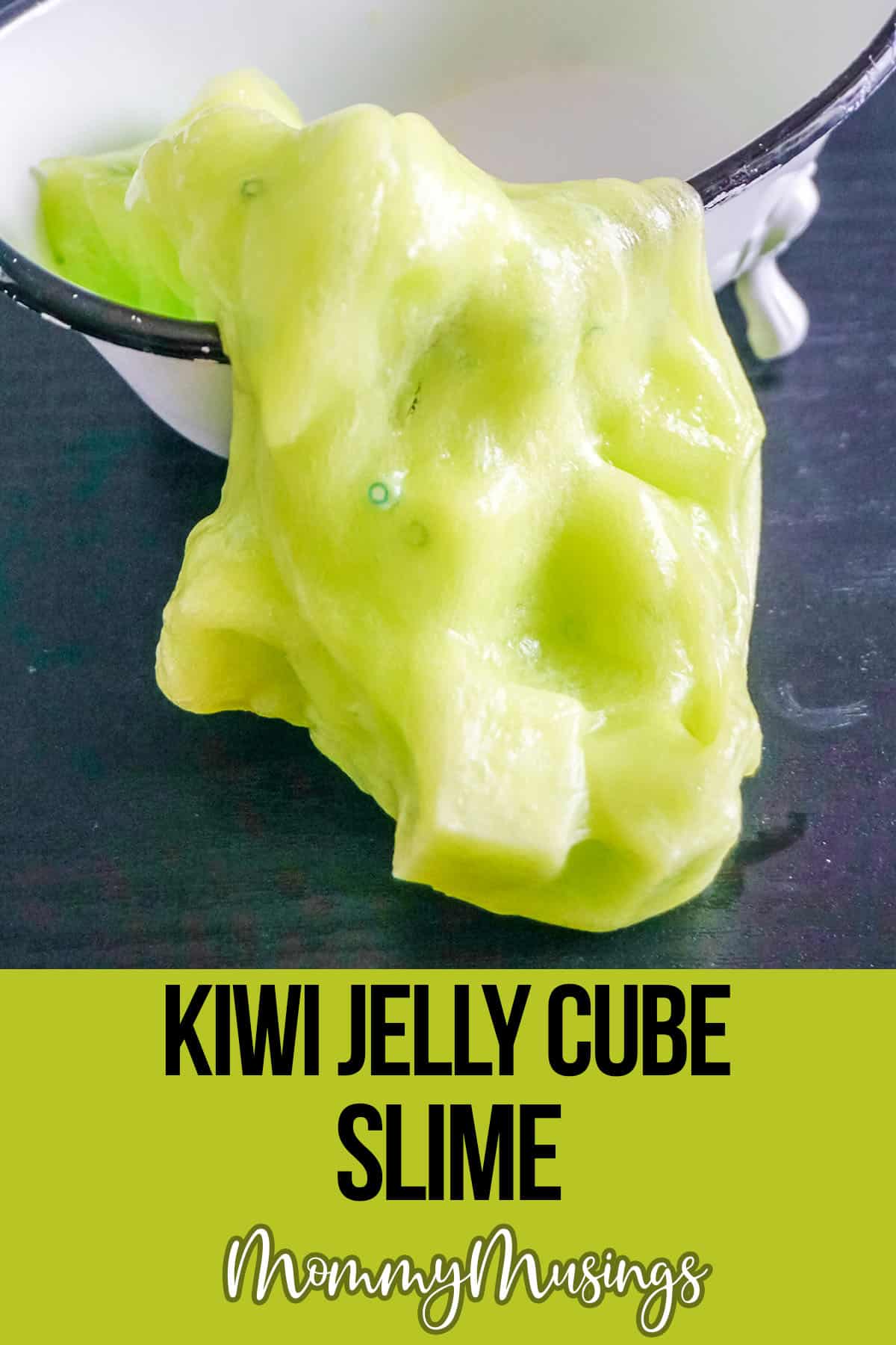 kiwi slime spilling onto a table with text which reads kiwi jelly cube slime