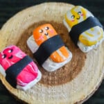 polymer clay sushi charms on a wood plate