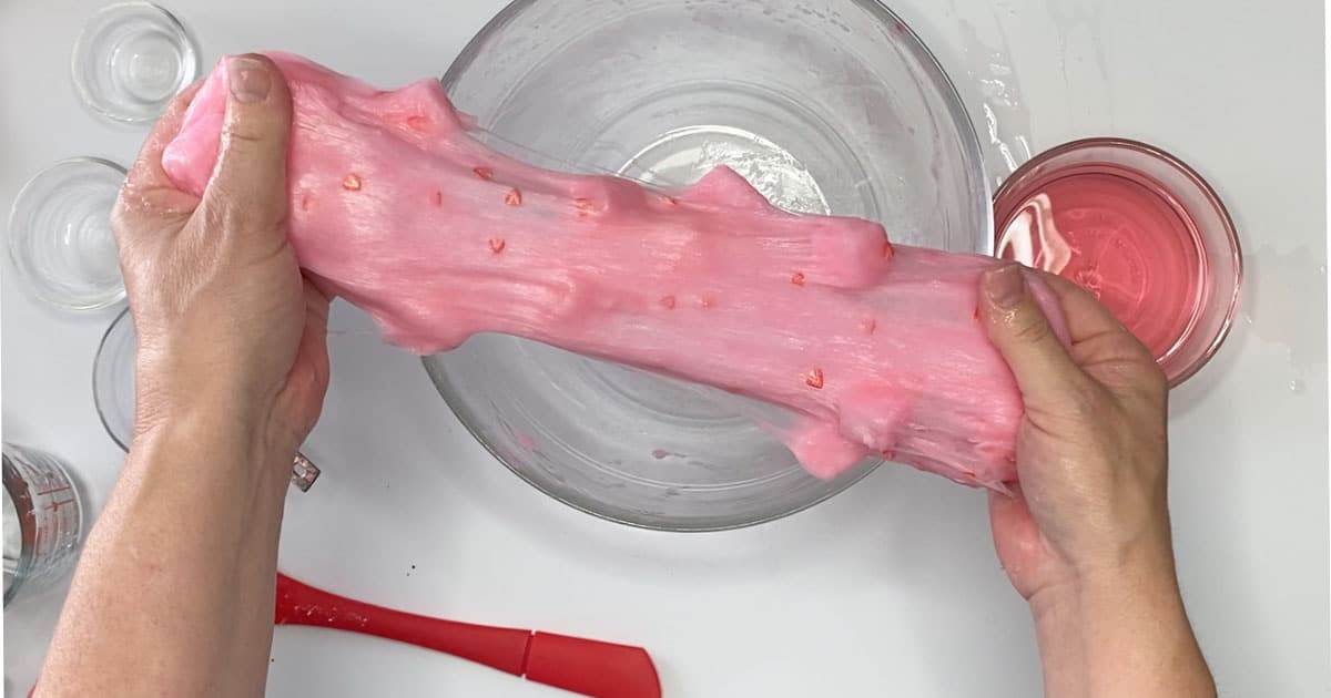 strawberry jelly cube slime being stretched over a bowl