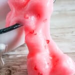 strawberry jelly cube slime spilling from a tiny bathtub onto the table