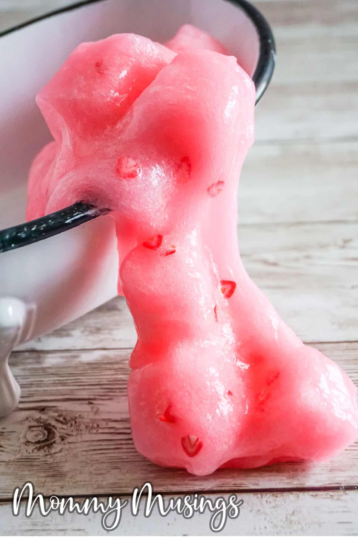 strawberry jelly cube slime spilling from a tiny bathtub onto the table